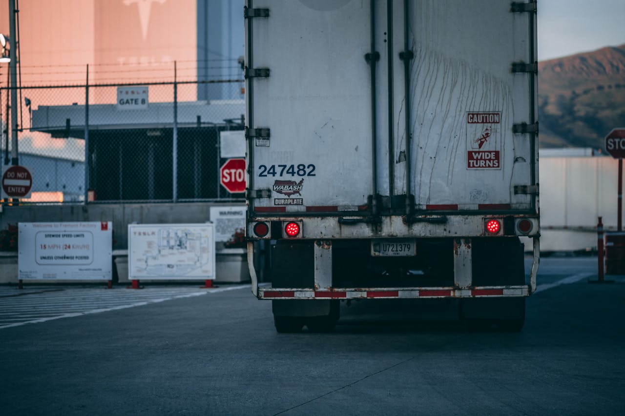 services-04 Semi truck parked at a loading dock with visible caution signs and industrial surroundings.
